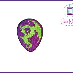 Peut inclure: Silhouette de dragon vert brodée sur un patch violet. Le dragon est enroulé sur lui-même avec ses ailes déployées.