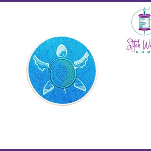 May include: A blue embroidered patch with a white outline of a sea turtle. The turtle is facing right and has a swirl design on its shell.