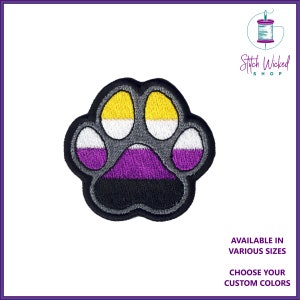 Pode incluir: Um remendo bordado com a forma de uma pata de cor cinza com as cores da bandeira do orgulho assexual: preto, roxo, branco, amarelo e cinza. O remendo está disponível em vários tamanhos e cores personalizadas.