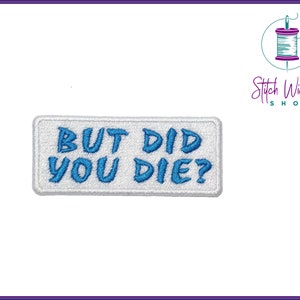 May include: A rectangular white embroidered patch with the text "BUT DID YOU DIE?" in blue. The patch has a white border and is set against a white background. The Stitch Wicked Shop logo is in the upper right corner.