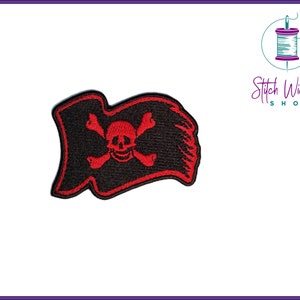 May include: Red embroidered pirate flag with a skull and crossbones on a black background.