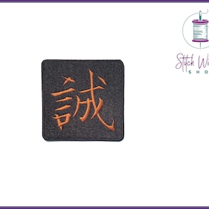 Puede incluir: Un parche cuadrado negro con el carácter chino para "remarkable" bordado en hilo naranja.