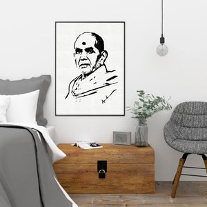 May include: Black and white portrait art print of a man with a shaved head and a dot on his forehead. The artwork is framed and hangs on a white wall above a wooden chest. A bed and chair are in the foreground.