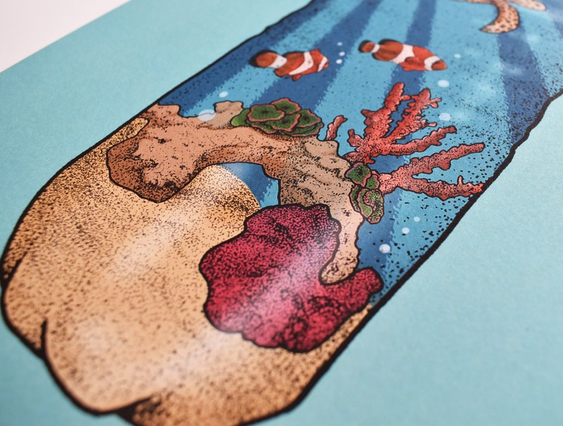 May include: A close-up of a glass bottle with a cork stopper. The bottle is filled with sand and coral, and there are two small orange and white fish swimming inside. The bottle is on a light blue background.