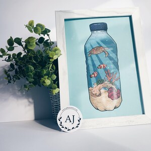 May include: A framed illustration of a plastic bottle filled with ocean life, including a sea turtle, coral, and clownfish. The bottle is on a light blue background.