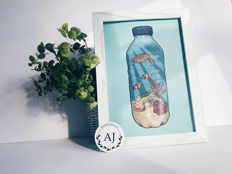 May include: A framed illustration of a plastic bottle filled with ocean life, including a sea turtle, coral, and clownfish. The bottle is on a light blue background.