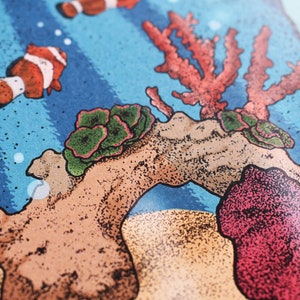 May include: A colorful illustration of an underwater scene with coral, rocks, and clownfish. The illustration is done in a stipple style, giving it a textured look.