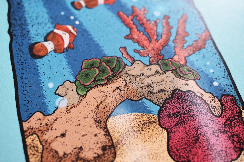May include: A colorful illustration of an underwater scene with coral, rocks, and clownfish. The illustration is done in a stipple style, giving it a textured look.