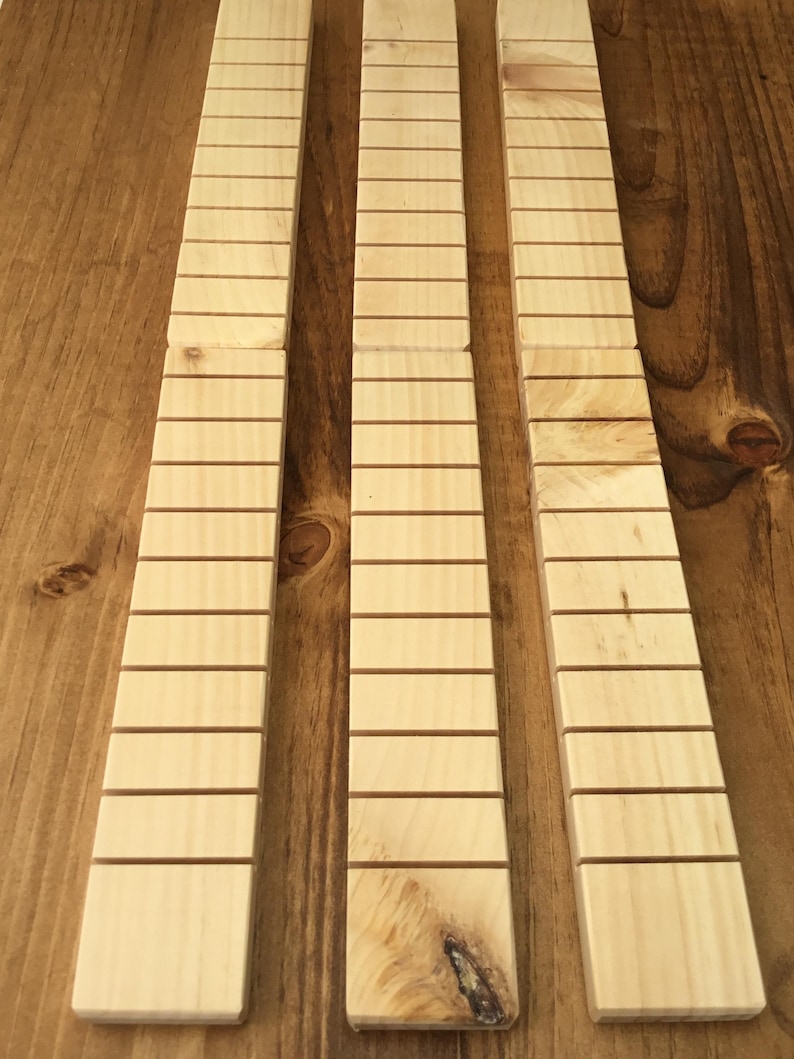 May include: Three wooden strips with evenly spaced grooves, likely for use in a craft project or as a decorative element.