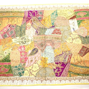 May include: A colorful patchwork wall tapestry with a variety of fabrics and embellishments. The tapestry features a mix of paisley patterns, floral motifs, and geometric designs. The colors are vibrant and include shades of pink, purple, green, yellow, and gold.