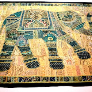 May include: A large tapestry featuring a patchwork elephant design in shades of teal, gold, and brown. The elephant is outlined in black and has intricate details throughout.