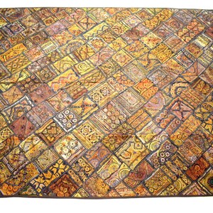 May include: A large tapestry with a patchwork design featuring a variety of geometric patterns in shades of gold, brown, and black.