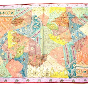 May include: A colourful patchwork quilt with a pink, red and white border. The quilt is made of various fabrics with floral and geometric patterns.