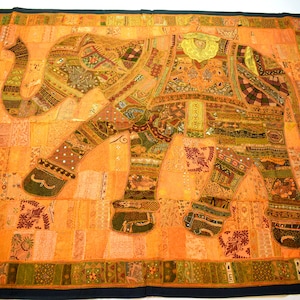 May include: A large, orange and green patchwork tapestry featuring an embroidered elephant design. The elephant is made up of various fabric scraps and is decorated with sequins and beads.