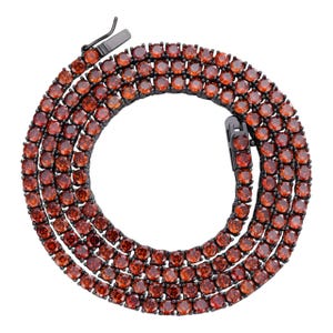 May include: A black chain necklace with a double row of orange round stones.