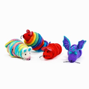 May include: Four felted animal figures including a white mouse wrapped in rainbow yarn, a red mouse wrapped in rainbow yarn, a solid red mouse, and a purple bat with teal-accented wings. Each figure features small black eyes and thin black whiskers.