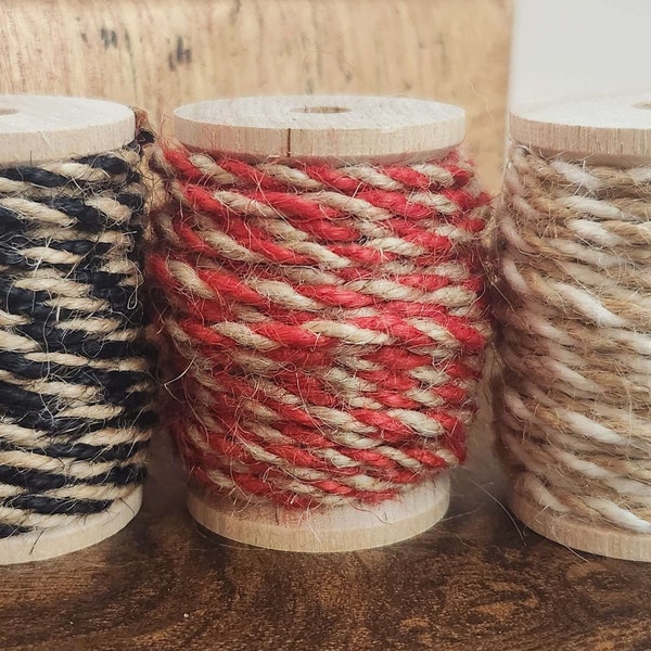 Twist,Jute Twine String Cord on a wood spool. 1/8" thickness, 5-yard bundle. Natural burlap fibers with white, red, black. Rustic packaging.