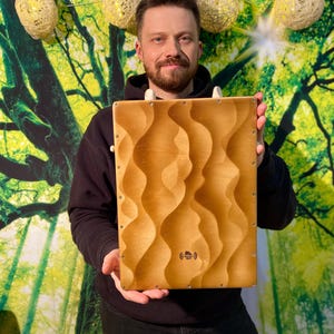 Cajon - percussion musical instrument in a travel version, mini hand-held wooden djembe drum with strings in the middle for jams
