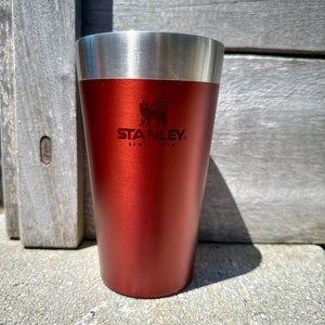 以下が含まれることがあります： 銀色の蓋と「Since 1913」の文字が入ったスタンレーのロゴが付いた、赤いステンレス製のスタンレーのトラベルマグです。