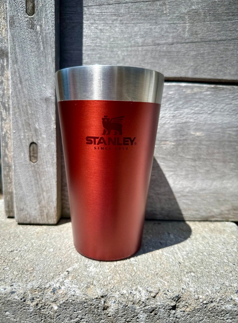 以下が含まれることがあります： 銀色の蓋と「Since 1913」の文字が入ったスタンレーのロゴが付いた、赤いステンレス製のスタンレーのトラベルマグです。