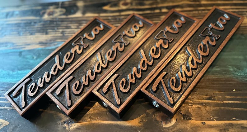 May include: Four wooden signs with the word "Tender" carved into them. The signs are dark brown with a light brown border.