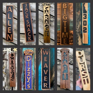 May include: Ten wooden tap handles with various names and designs. The handles are all approximately 12 inches long and 3 inches wide. The names on the handles include "Allen", "Jack Shack", "The Garage", "Big Time", "302", "Cletus", "Dizzy's Brew", "Weaver", "Draft", and "Durst".
