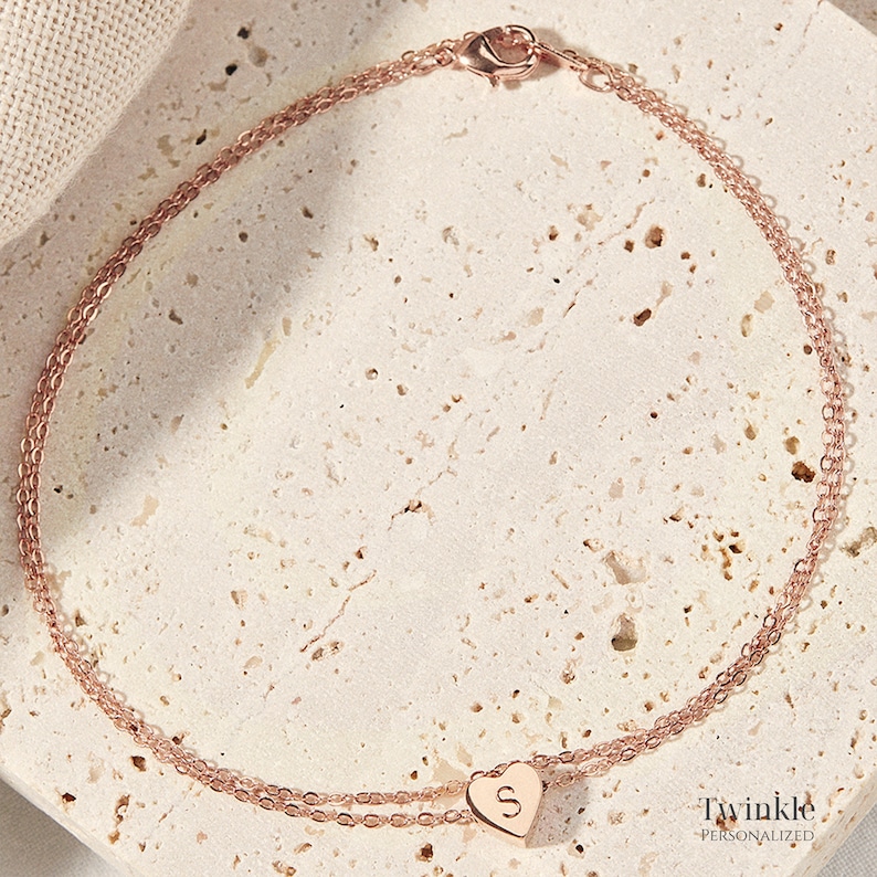 K&ouml;nnte beinhalten: Ein zartes Armband aus ros&eacute;goldener Kette mit einem kleinen Herz-Anh&auml;nger mit dem Buchstaben "S". Das Armband besteht aus zwei &uuml;bereinanderliegenden Ketten und hat einen Karabinerverschluss. Twinkle Personalisiert.