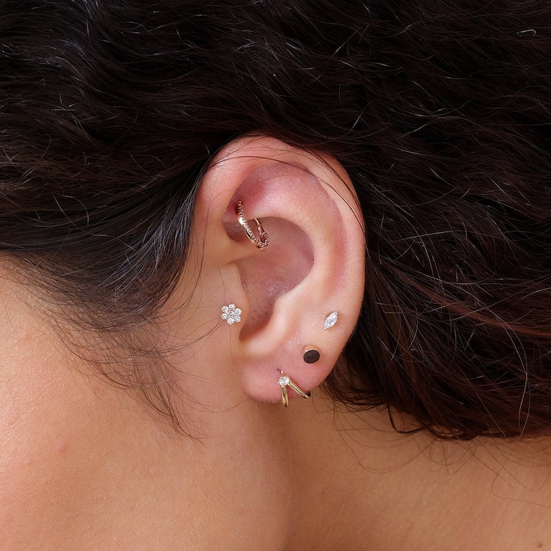 a close up of a person wearing a pair of ear piercings