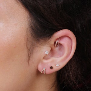 a close up of a person wearing a pair of ear piercings