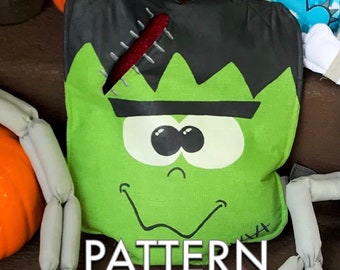May include: Green and black Frankenstein monster-themed trick-or-treat bag with a stitched seam and googly eyes. The bag says "PATTERN" at the bottom.