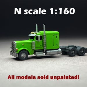 Könnte beinhalten: Ein grüner Modell-LKW im Maßstab N 1:160. Der Miniatur-LKW hat einen detaillierten Frontgrill, silberne Auspuffrohre und schwarze Räder. Der Text "All models sold unpainted!" wird darunter angezeigt.