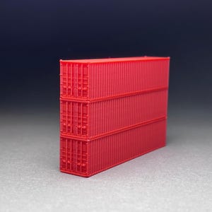 May include: Three red shipping containers stacked on top of each other. The containers are made of metal and have a corrugated surface.