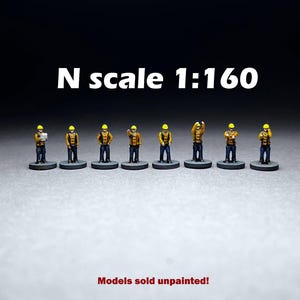 May include: Eight unpainted miniature figures of construction workers in N scale 1:160. The figures are wearing yellow hard hats and orange vests. Models sold unpainted.