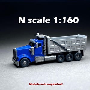 May include: A blue and silver N scale model dump truck. The truck is 1:160 scale and is sold unpainted.