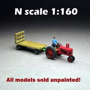 May include: Miniature red tractor with a yellow trailer, and a figure in a blue shirt and brown hat. The tractor has black wheels and a red engine. The trailer is made of wood. The text on the image says "N scale 1:160" and "All models sold unpainted!"