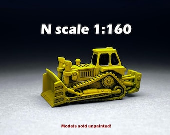 May include: A yellow N scale 1:160 model of a bulldozer with a blade. Models sold unpainted.