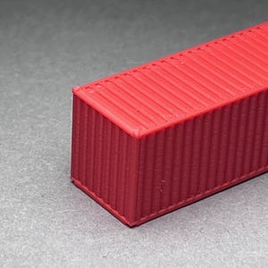 May include: A red shipping container model with a corrugated metal texture.