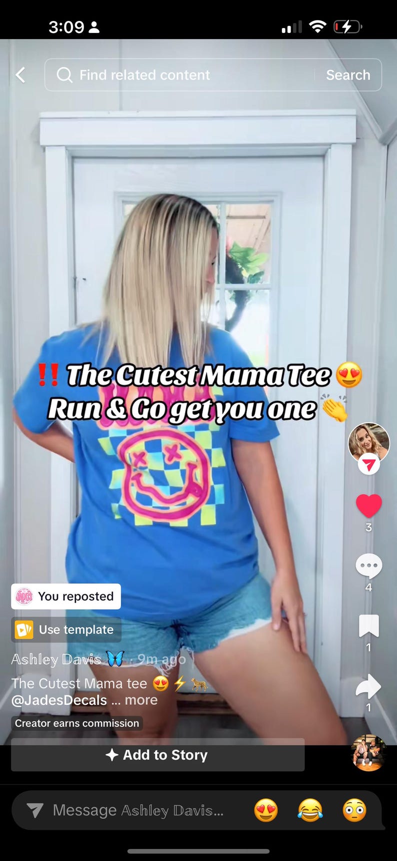 May include: A woman wearing a blue t-shirt with a pink and green smiley face graphic and the text "The Cutest Mama Tee" on it. She is also wearing denim shorts.