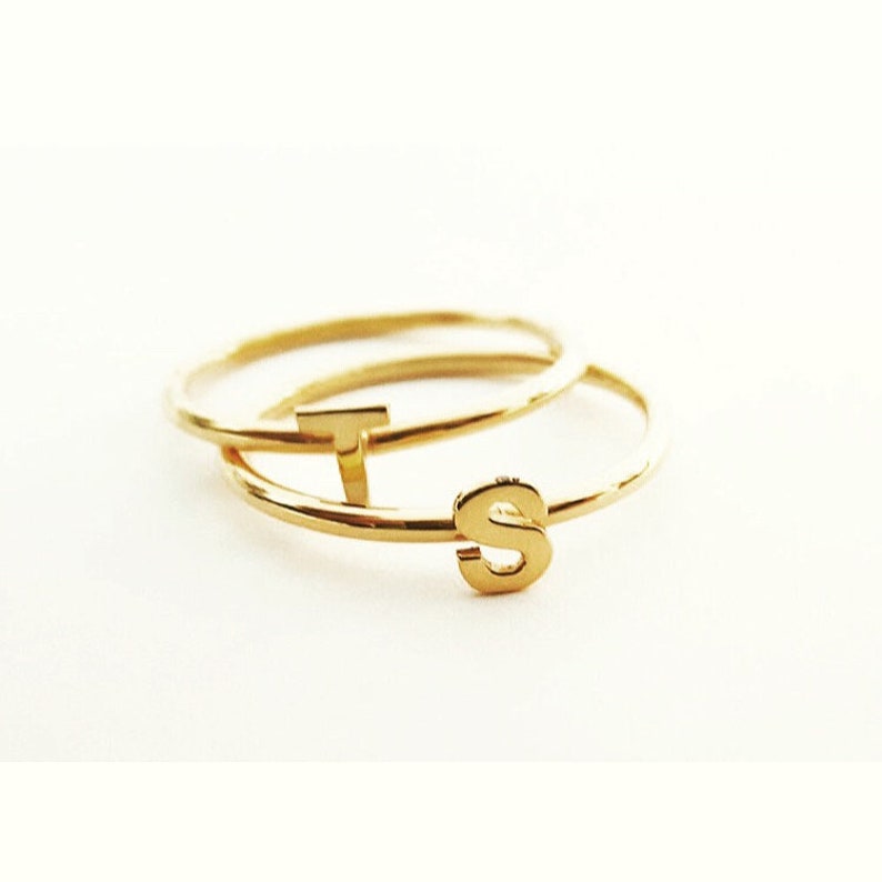 May include: Two gold rings with the letters "T" and "S" on them.