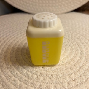 Puede incluir: Shaker de plástico amarillo con tapa blanca y una etiqueta blanca que dice "DIAMOND".