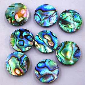 Peut inclure: Huit cabochons ronds en nacre d'ormeau irisée avec une variété de motifs bleus, verts et dorés.