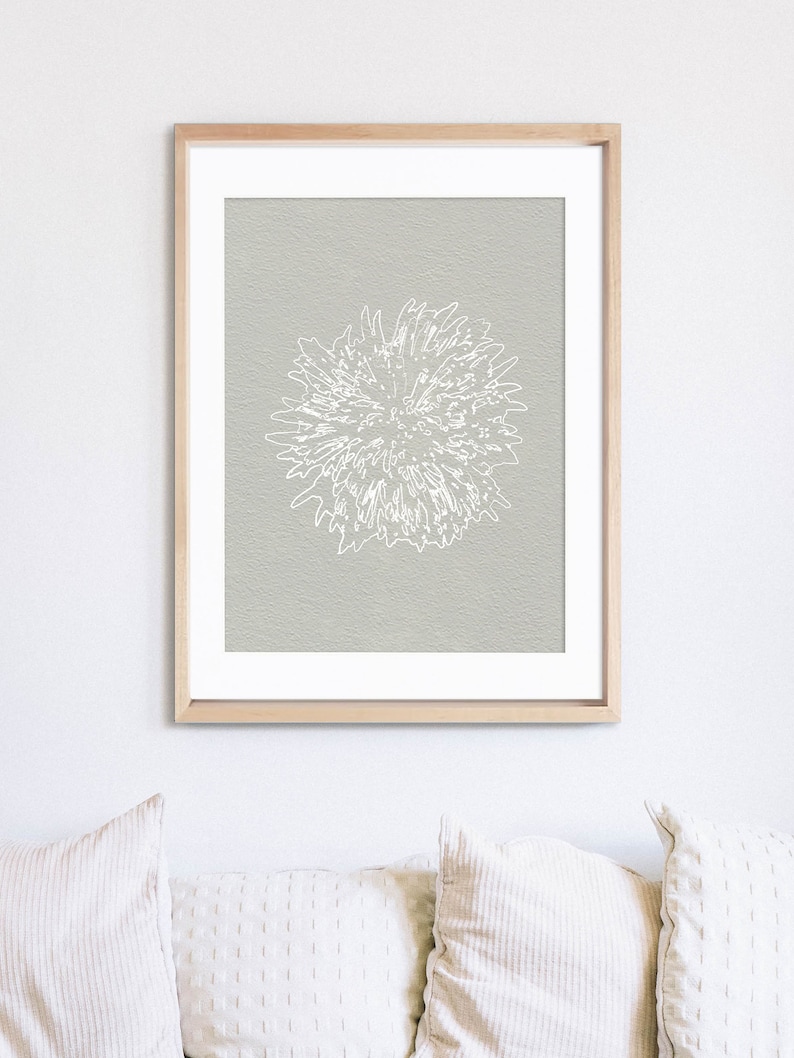 K&ouml;nnte beinhalten: Ein gerahmter Druck einer wei&szlig;en stilisierten Blume auf hellgrauem Hintergrund.