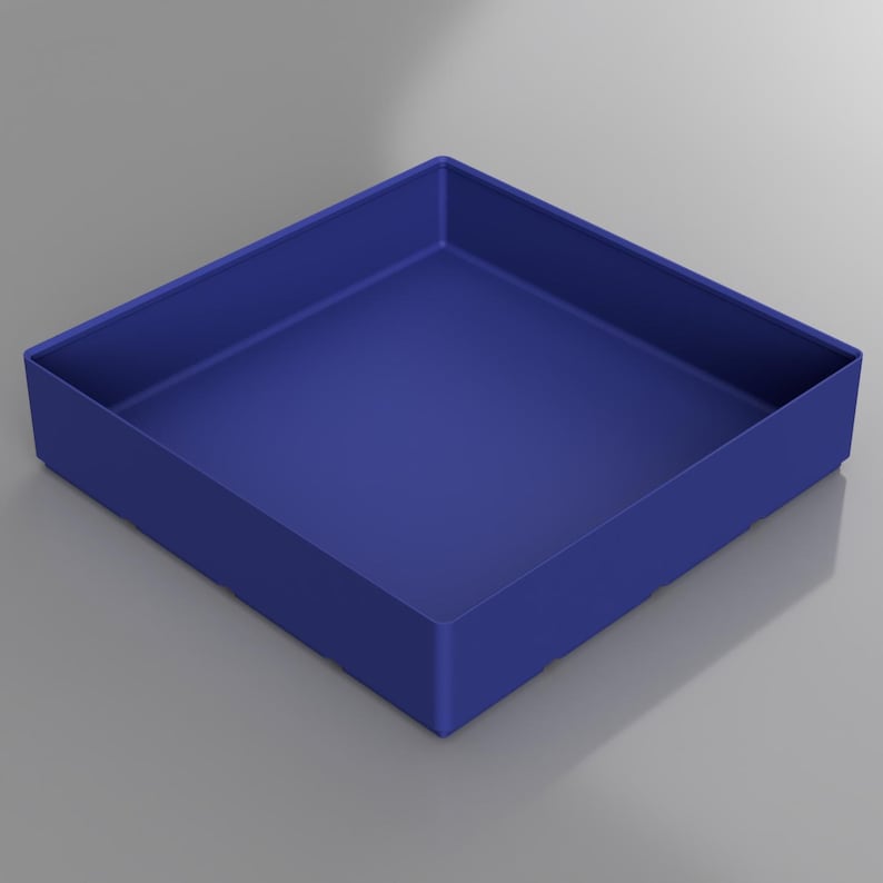 May include: A square, cobalt blue tray with a low profile. The tray has a simple, modern design with straight sides and a flat bottom. The color is a solid, matte finish, and the tray appears to be made of a solid material.