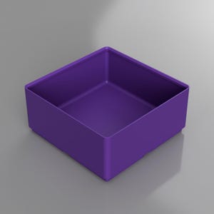 May include: A square, purple storage box with a low profile. The box is a solid color and has a simple, modern design. The interior and exterior are the same shade of purple. The box is sitting on a gray surface.
