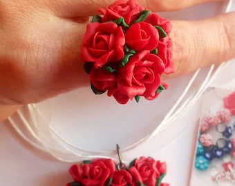 Peut inclure: Un ensemble de bague et collier en argile polymère composé de roses rouges. La bague présente un groupe de roses rouges avec des feuilles vertes, tandis que le collier présente un groupe de roses rouges en forme de cœur avec des feuilles vertes.