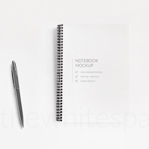 May include: A white notebook mockup with a black spiral binding. The notebook is on a white background with a pen next to it. The text on the notebook says "Notebook Mockup" and lists features: "High Resolution Files", "PSD File + JPEG File", and "Smart Objects".