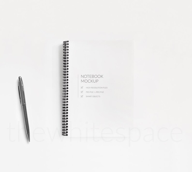 May include: A white notebook mockup with a black spiral binding. The notebook is on a white background with a pen next to it. The text on the notebook says "Notebook Mockup" and lists features: "High Resolution Files", "PSD File + JPEG File", and "Smart Objects".