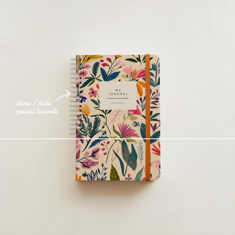 May include: A spiral bound journal with a floral pattern in shades of pink, yellow, green, and blue. The cover reads "My Journal" in a white rectangle.