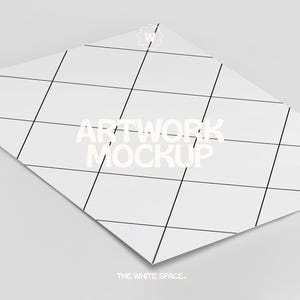 May include: A white sheet of paper with a grid pattern and the text "ARTWORK MOCKUP" in white. The text "THE WHITE SPACE." is at the bottom of the page.