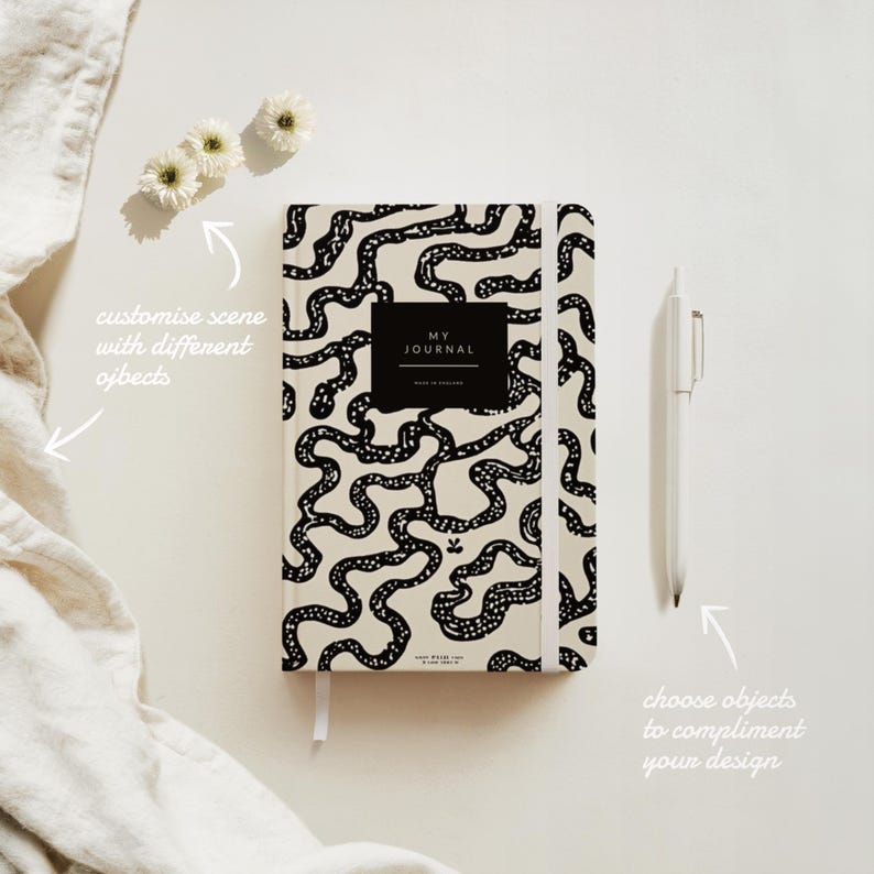 May include: A black and white journal with a patterned cover featuring a maze-like design. The cover also has the text "MY JOURNAL" in a black rectangle. The journal is lying flat on a white surface.